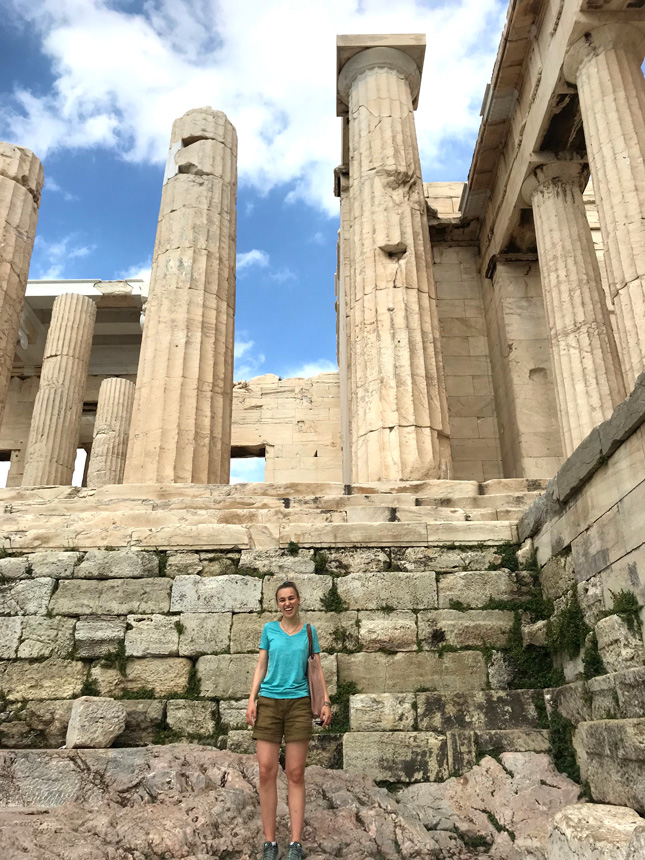 A college student stands in front of the Pantheon in Greece