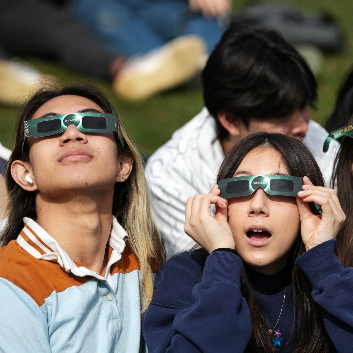 Two+students+watch+the+eclipse+through+¼ϲʿ-branded+glasses.